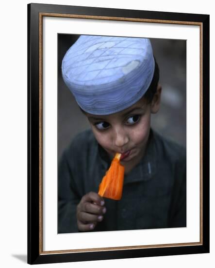 Boy Eats an Ice Lolly in a Neighborhood on the Outskirts of Islamabad, Pakistan-null-Framed Photographic Print