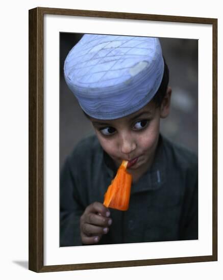 Boy Eats an Ice Lolly in a Neighborhood on the Outskirts of Islamabad, Pakistan-null-Framed Photographic Print