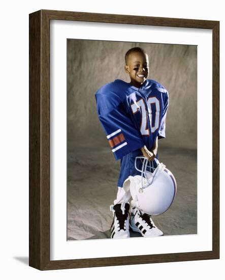 Boy in an Oversized Football Uniform Holding a Helmet-null-Framed Photographic Print