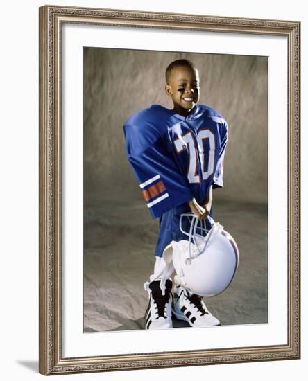 Boy in an Oversized Football Uniform Holding a Helmet-null-Framed Photographic Print