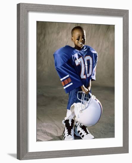 Boy in an Oversized Football Uniform Holding a Helmet-null-Framed Photographic Print