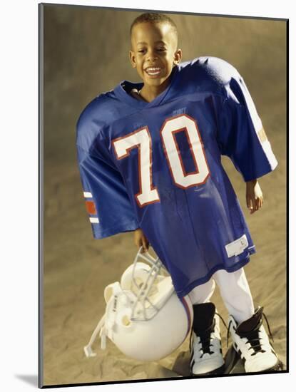 Boy in an Oversized Football Uniform Holding a Helmet-null-Mounted Photographic Print