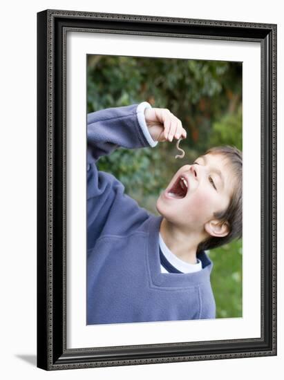 Boy Pretending To Eat An Earthworm-Ian Boddy-Framed Photographic Print