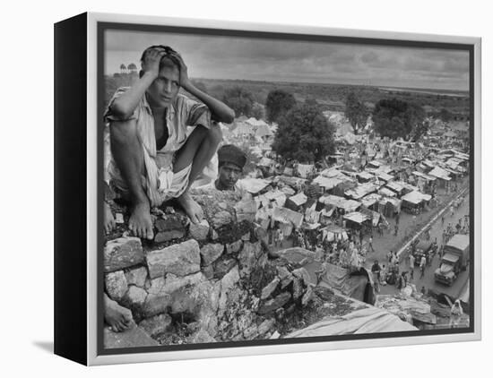 Boy Sitting on Rock Ledge Above Refugee Camp-Margaret Bourke-White-Framed Premier Image Canvas