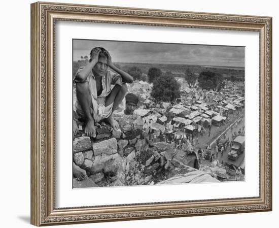 Boy Sitting on Rock Ledge Above Refugee Camp-Margaret Bourke-White-Framed Photographic Print