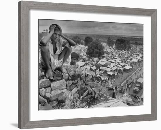 Boy Sitting on Rock Ledge Above Refugee Camp-Margaret Bourke-White-Framed Photographic Print