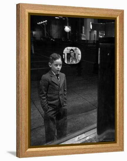 Boy Watching TV on Store Window Set, Glass Reflects the Image Off TV Screen-Ralph Morse-Framed Premier Image Canvas