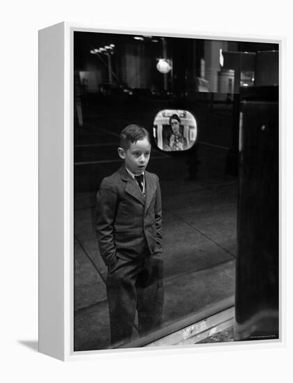 Boy Watching TV on Store Window Set, Glass Reflects the Image Off TV Screen-Ralph Morse-Framed Premier Image Canvas