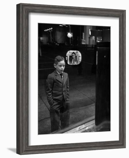 Boy Watching TV on Store Window Set, Glass Reflects the Image Off TV Screen-Ralph Morse-Framed Photographic Print