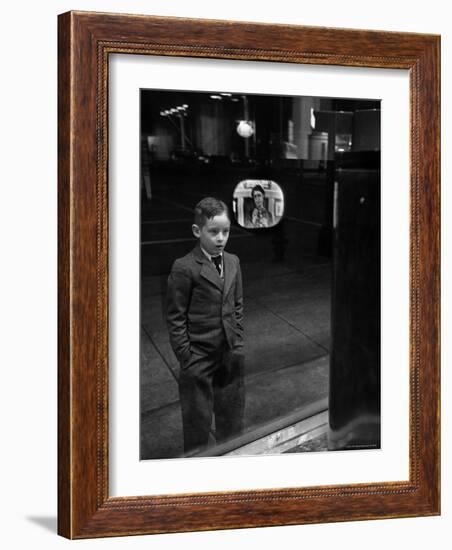 Boy Watching TV on Store Window Set, Glass Reflects the Image Off TV Screen-Ralph Morse-Framed Photographic Print