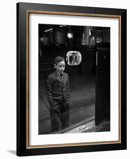 Boy Watching TV on Store Window Set, Glass Reflects the Image Off TV Screen-Ralph Morse-Framed Photographic Print