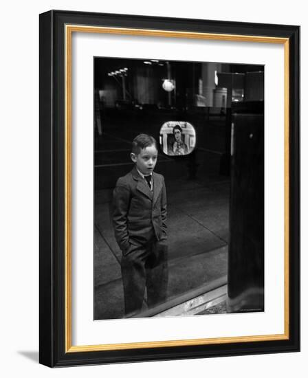 Boy Watching TV on Store Window Set, Glass Reflects the Image Off TV Screen-Ralph Morse-Framed Photographic Print
