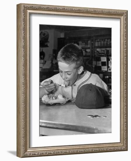 Boy Wearing Baseball Uniform Eating Banana Split at Soda Fountain Counter-Joe Scherschel-Framed Photographic Print