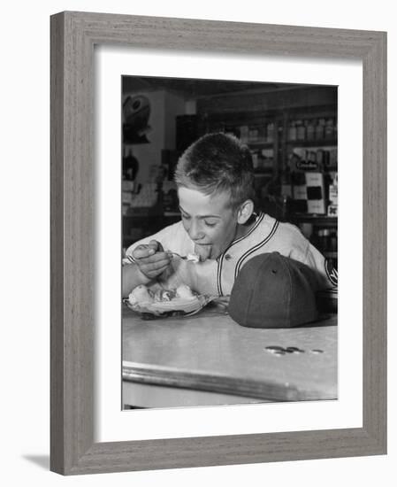 Boy Wearing Baseball Uniform Eating Banana Split at Soda Fountain Counter-Joe Scherschel-Framed Photographic Print