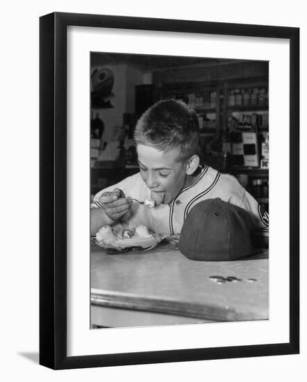 Boy Wearing Baseball Uniform Eating Banana Split at Soda Fountain Counter-Joe Scherschel-Framed Photographic Print