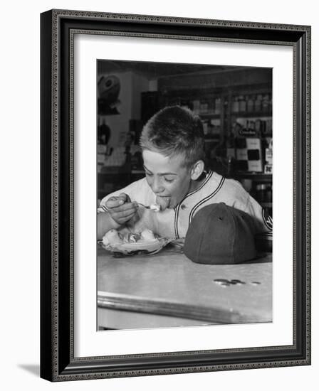 Boy Wearing Baseball Uniform Eating Banana Split at Soda Fountain Counter-Joe Scherschel-Framed Photographic Print