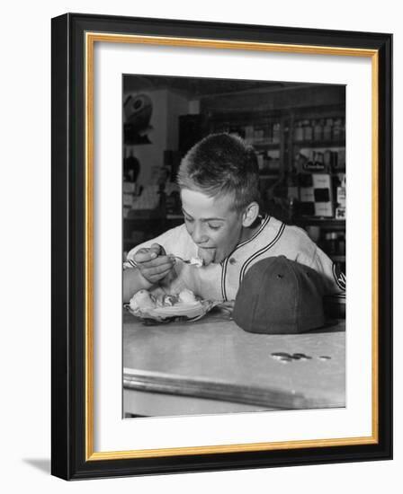 Boy Wearing Baseball Uniform Eating Banana Split at Soda Fountain Counter-Joe Scherschel-Framed Photographic Print