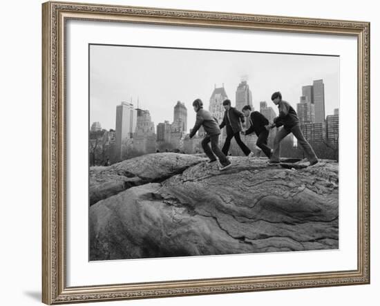 Boys Climbing About on Rock Formation in Central Park as Essex House Looms Amidst Skyline of City-Bill Ray-Framed Photographic Print