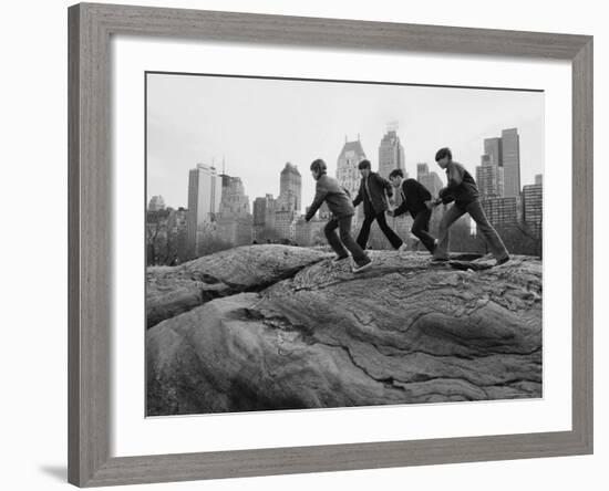 Boys Climbing About on Rock Formation in Central Park as Essex House Looms Amidst Skyline of City-Bill Ray-Framed Photographic Print