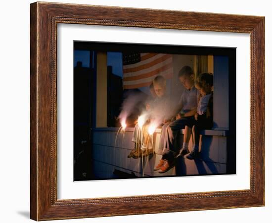 Boys Sitting on Porch Holding Sparklers, with US Flag in Back, During Independence Day Celebration-Nat Farbman-Framed Photographic Print