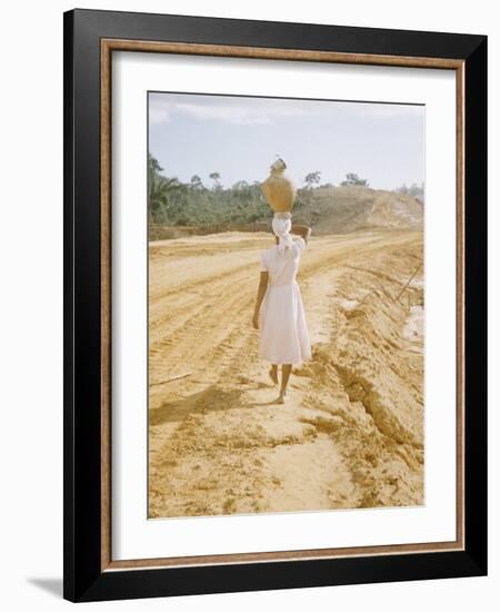 Brazilian Woman Walking Down a Sandy Road Carrying a Large Jar on Her Head-Dmitri Kessel-Framed Photographic Print