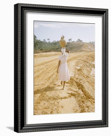 Brazilian Woman Walking Down a Sandy Road Carrying a Large Jar on Her Head-Dmitri Kessel-Framed Photographic Print