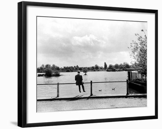 British Actor Alec Guinness Sitting Alone by Lake in a Park-Cornell Capa-Framed Premium Photographic Print