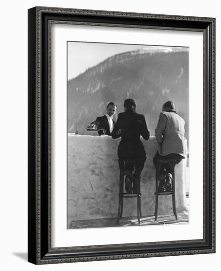 British Couple on High Stools at Ice Bar Outdoors at Grand Hotel as Waiter Pours Them Drinks-Alfred Eisenstaedt-Framed Photographic Print
