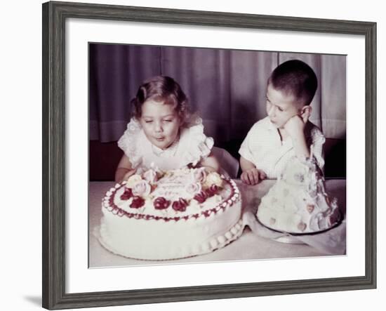 Brother Watches His Sister Blow Out Candles on Birthday Cake, Ca. 1956-null-Framed Photographic Print