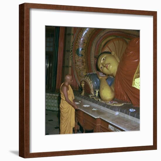 Buddhist priest before the image of a reclining Buddha. Artist: Unknown-Unknown-Framed Photographic Print