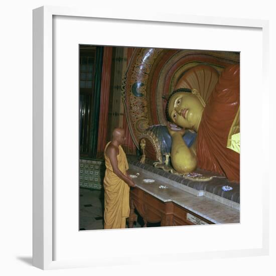 Buddhist priest before the image of a reclining Buddha. Artist: Unknown-Unknown-Framed Photographic Print