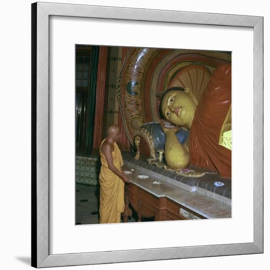 Buddhist priest before the image of a reclining Buddha. Artist: Unknown-Unknown-Framed Photographic Print