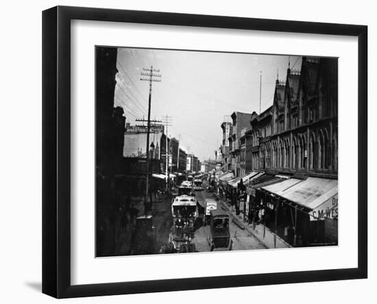 Bustling View of Fulton St, with Rows of Shops and Horse Drawn Carriages-Wallace G^ Levison-Framed Photographic Print