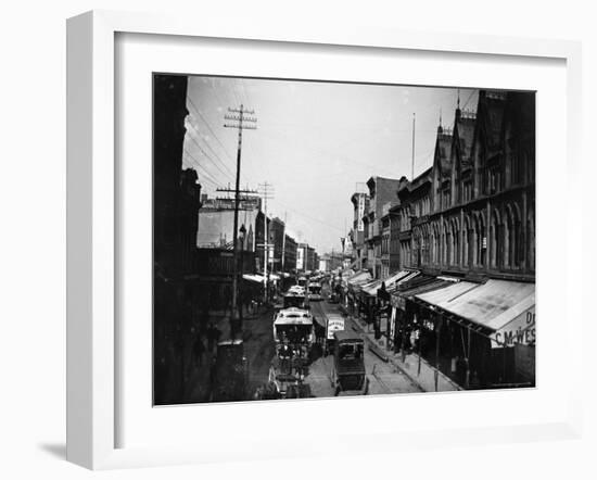 Bustling View of Fulton St, with Rows of Shops and Horse Drawn Carriages-Wallace G^ Levison-Framed Photographic Print