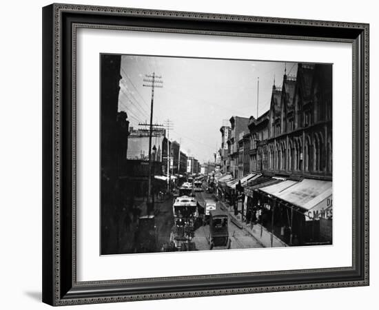 Bustling View of Fulton St, with Rows of Shops and Horse Drawn Carriages-Wallace G^ Levison-Framed Photographic Print