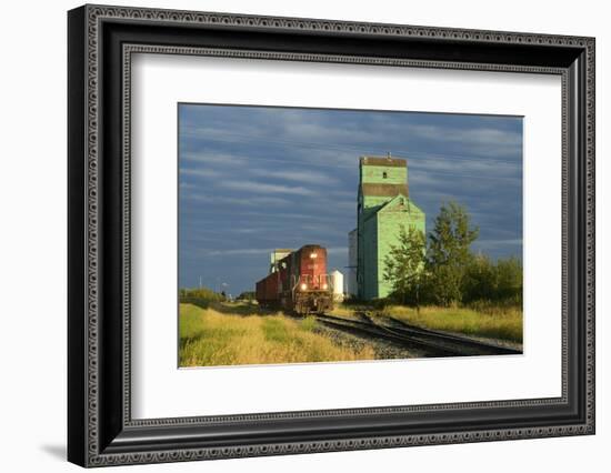 Canada, Alberta, Sexsmith. Grain elevators and train on railroad tracks.-Jaynes Gallery-Framed Photographic Print