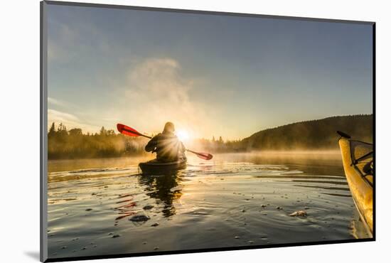 Canada, British Columbia. A kayaker paddles in morning mist on a Canadian lake.-Gary Luhm-Mounted Photographic Print