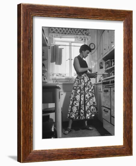 Career Girl Hostedd Joan Wilson in skirt and sleeveless blouse cooking in kitchen-Nina Leen-Framed Photographic Print