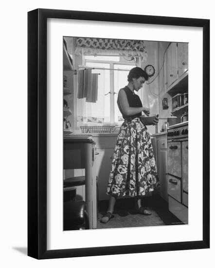 Career Girl Hostedd Joan Wilson in skirt and sleeveless blouse cooking in kitchen-Nina Leen-Framed Photographic Print