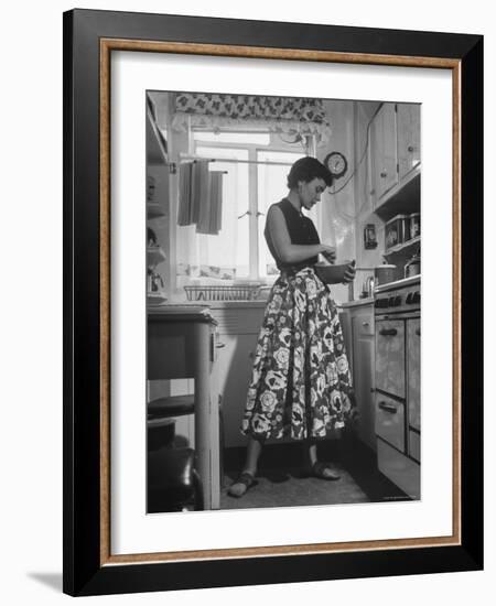 Career Girl Hostedd Joan Wilson in skirt and sleeveless blouse cooking in kitchen-Nina Leen-Framed Photographic Print