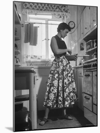 Career Girl Hostedd Joan Wilson in skirt and sleeveless blouse cooking in kitchen-Nina Leen-Mounted Photographic Print