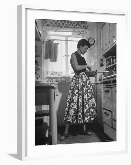 Career Girl Hostedd Joan Wilson in skirt and sleeveless blouse cooking in kitchen-Nina Leen-Framed Photographic Print