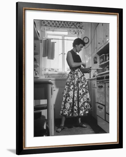 Career Girl Hostedd Joan Wilson in skirt and sleeveless blouse cooking in kitchen-Nina Leen-Framed Photographic Print