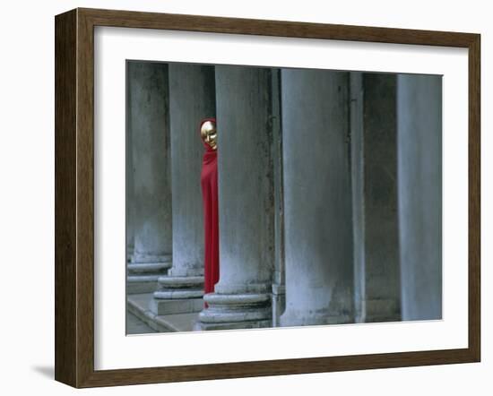 Carnival Model in Red Cape and Gold Mask Peering from Columns in St. Mark's Square, Veneto, Italy-Lee Frost-Framed Photographic Print