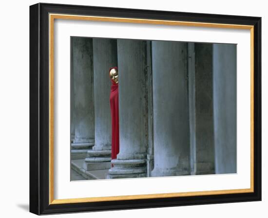 Carnival Model in Red Cape and Gold Mask Peering from Columns in St. Mark's Square, Veneto, Italy-Lee Frost-Framed Photographic Print