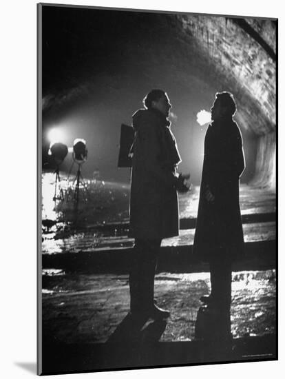 Carol Reed Coaching Orson Welles as They Stand Against Floodlights During Filming "The Third Man."-William Sumits-Mounted Premium Photographic Print