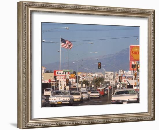 Cars Moving Along Congested Street, Littered with Signs, Billboards and Traffic Directives-Michael Rougier-Framed Photographic Print