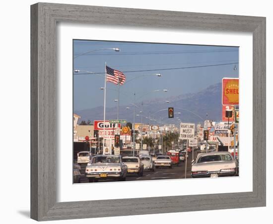Cars Moving Along Congested Street, Littered with Signs, Billboards and Traffic Directives-Michael Rougier-Framed Photographic Print