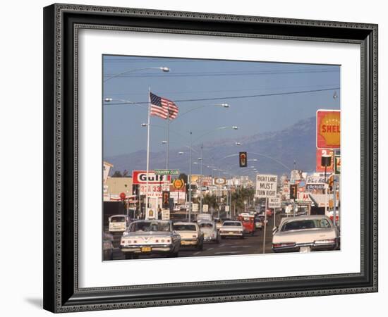 Cars Moving Along Congested Street, Littered with Signs, Billboards and Traffic Directives-Michael Rougier-Framed Photographic Print