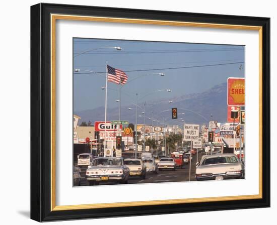 Cars Moving Along Congested Street, Littered with Signs, Billboards and Traffic Directives-Michael Rougier-Framed Photographic Print